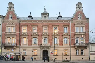 a large brick building with people standing outside of it at Vintage Apartment Gertrudy street in Kraków