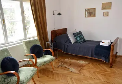 a bedroom with a bed and two chairs at Castle View Boutique Apartment in Kraków