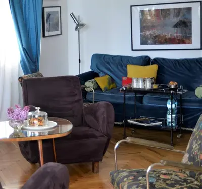 a living room with a blue couch and a table at Castle View Boutique Apartment in Kraków