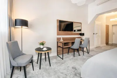 a hotel room with a bed and a table and chairs at Vinfort Aparthotel in Kraków