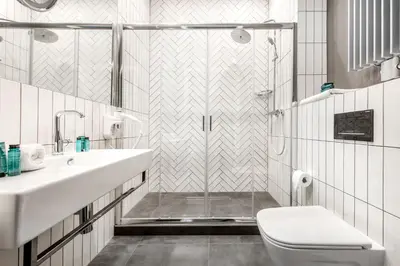 a bathroom with a shower and a toilet and a sink at Vinfort Aparthotel in Kraków