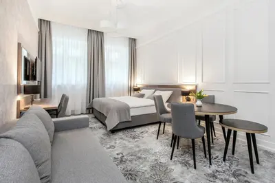a hotel room with a bed and a table and chairs at Vinfort Aparthotel in Kraków