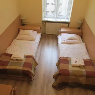 two beds in a small room with a window at CDR in Kraków