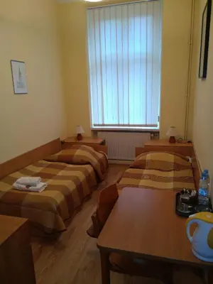 a room with two beds and a table and a window at CDR in Kraków