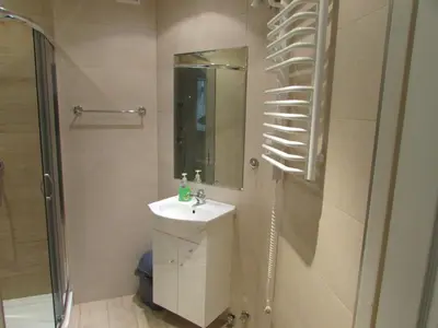 a bathroom with a sink and a shower and a mirror at CDR in Kraków