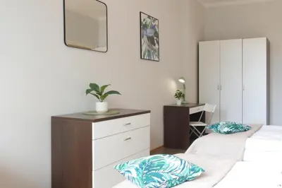 a bedroom with two beds and a dresser with a mirror at Unique apartments Krasinskiego street in Kraków