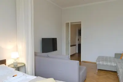 a white living room with a tv and a couch at Unique apartments Krasinskiego street in Kraków