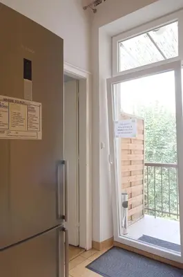 a kitchen with a refrigerator and a large window at Unique apartments Krasinskiego street in Kraków