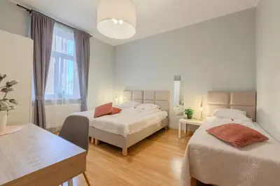 a white room with two beds and a window at Castle View Krasinskiego Avenue in Kraków