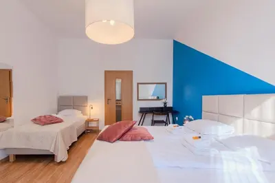 a bedroom with two beds and a blue wall at Castle View Krasinskiego Avenue in Kraków
