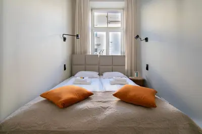 a bed with two orange pillows in a bedroom at Apartments Wróblewskiego Street in Kraków