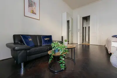 a living room with a black couch and a table at Apartments Wróblewskiego Street in Kraków