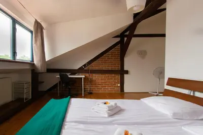 a bedroom with a white bed and a brick wall at Apartments Wróblewskiego Street in Kraków