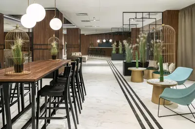 a lobby with a long table and chairs at Metropolo by Golden Tulip Krakow in Kraków