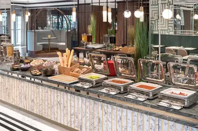 a buffet line with food on a table in a restaurant at Metropolo by Golden Tulip Krakow in Kraków