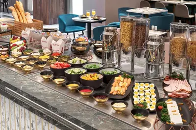 a buffet with many different types of food on a table at Metropolo by Golden Tulip Krakow in Kraków
