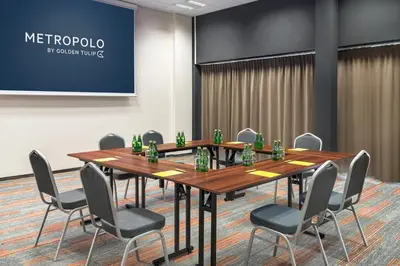 a conference room with a long table and chairs at Metropolo by Golden Tulip Krakow in Kraków
