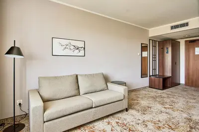 a living room with a couch and a lamp at Metropolo by Golden Tulip Krakow in Kraków