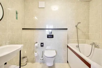 a bathroom with a toilet and a tub and a sink at Metropolo by Golden Tulip Krakow in Kraków