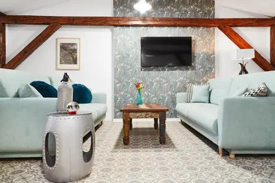 a living room with two blue couches and a tv at Quiet Loft Michalowskiego Street in Kraków