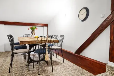 a dining room with a table and chairs and a clock at Quiet Loft Michalowskiego Street in Kraków