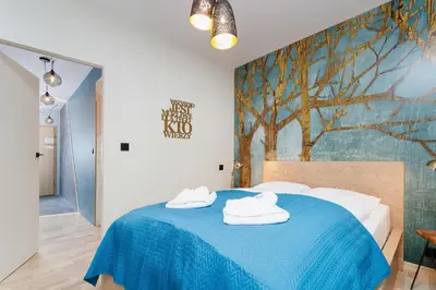 a bedroom with a blue bed with towels on it at Apartments Kraków Masarska Free Parking by Noclegi Renters in Kraków