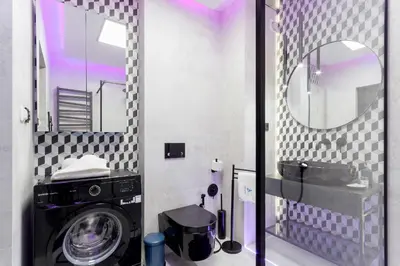 a bathroom with a washing machine and a mirror at Apartments Kraków Masarska Free Parking by Noclegi Renters in Kraków