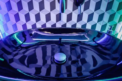 a blue sink in a bathroom with a checkered wall at Apartments Kraków Masarska Free Parking by Noclegi Renters in Kraków