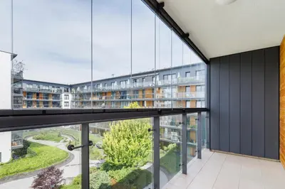 an apartment with a balcony with glass walls at Apartments Kraków Masarska Free Parking by Noclegi Renters in Kraków