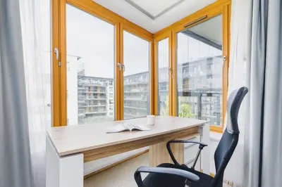 an office with a desk and a chair in front of a window at Apartments Kraków Masarska Free Parking by Noclegi Renters in Kraków