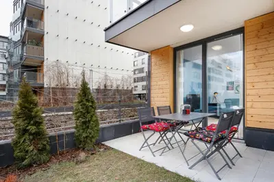 a patio with a table and chairs in front of a building at Apartments Kraków Masarska Free Parking by Noclegi Renters in Kraków