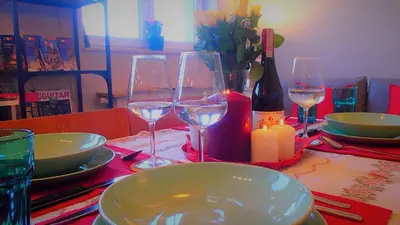 a table with four wine glasses and a candle at Cracovia Panorama East Apartment Vermelo in Kraków