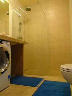 a bathroom with a shower and a washing machine at Cracovia Panorama East Apartment Vermelo in Kraków