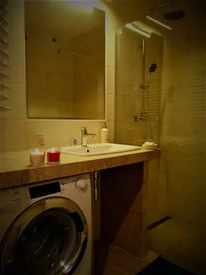 a bathroom with a washing machine and a sink at Cracovia Panorama East Apartment Vermelo in Kraków