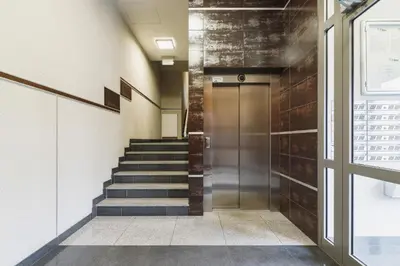a hallway of a building with stairs and a door at Apartments Kraków Wiślane Tarasy by Noclegi Renters in Kraków