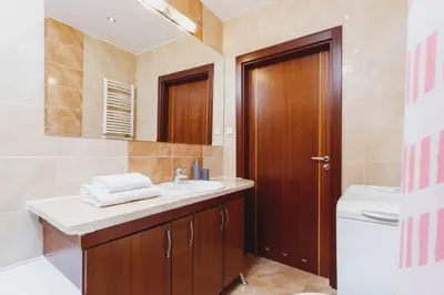 a bathroom with a sink and a toilet and a mirror at Apartments Kraków Wiślane Tarasy by Noclegi Renters in Kraków