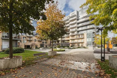 a park with a bench and trees in front of a building at Apartments Kraków Wiślane Tarasy by Noclegi Renters in Kraków