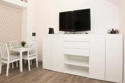 a living room with a white entertainment center with a tv at caput mundi in Kraków