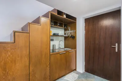 a kitchen with wooden cabinets and a sink at caput mundi in Kraków