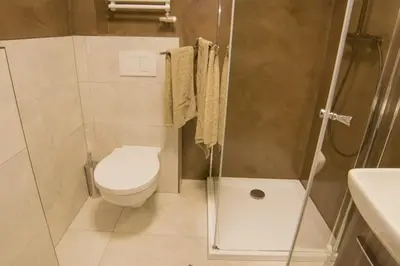 a small bathroom with a toilet and a shower at caput mundi in Kraków