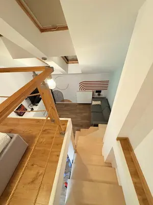 an attic room with a staircase leading to a living room at caput mundi in Kraków