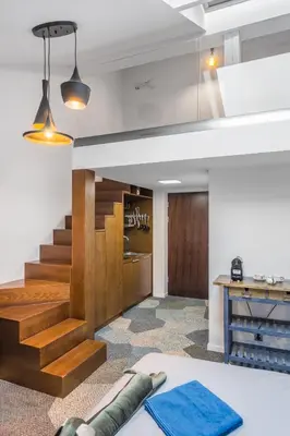 a living room with a staircase and a table at caput mundi in Kraków