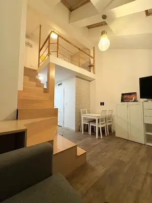 a living room with a staircase and a dining room at caput mundi in Kraków