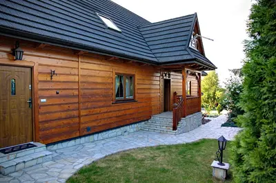 a wooden cabin with a porch and a door at Jankówka in Wieliczka