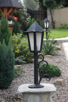 a black lampost on a stone block in a garden at Jankówka in Wieliczka