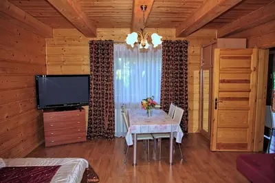 a dining room with a table and a flat screen tv at Jankówka in Wieliczka