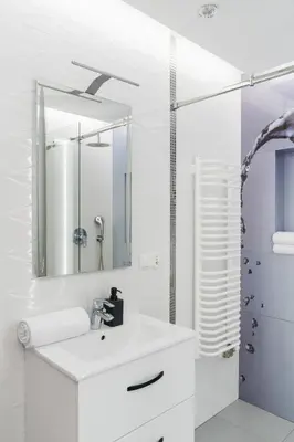 a white bathroom with a sink and a mirror at Native Apartments Masarska 8 in Kraków