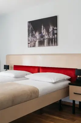 a bedroom with two beds and a painting on the wall at Native Apartments Masarska 8 in Kraków