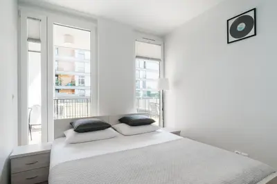 a white bedroom with a large bed with two pillows at Native Apartments Masarska 8 in Kraków