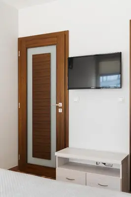 a bedroom with a flat screen tv and a bed at Native Apartments Masarska 8 in Kraków